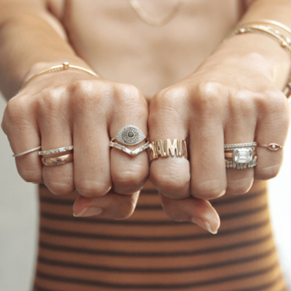 14K Gold Evil Eye and Baguette Diamond and Cigar Band Rings on hand